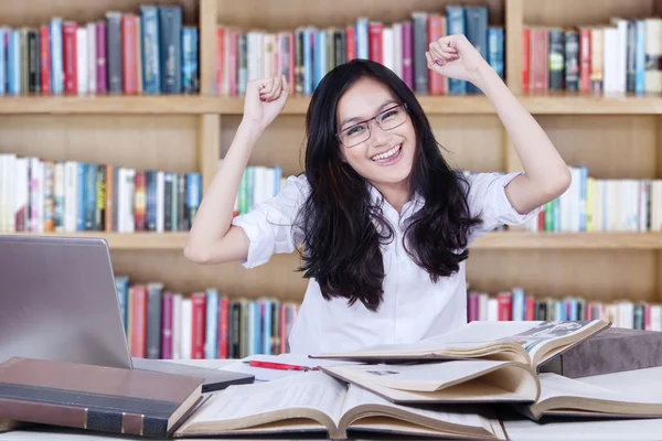 Teenage girl expressing happy in the library — Stock fotografie