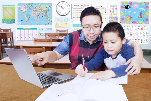 Junger Lehrer führt seinen Schüler zum Lernen — Stockfoto