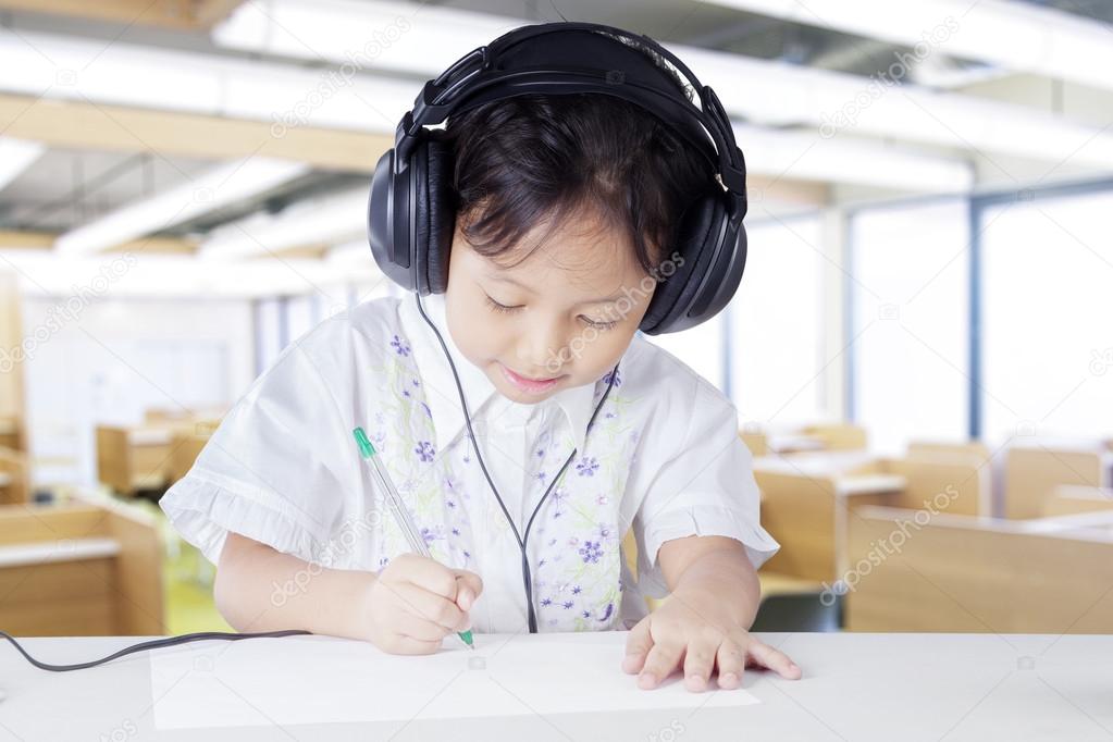 Child wearing earphones in listening lesson