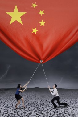 Businesspeople pulling down a chinese flag