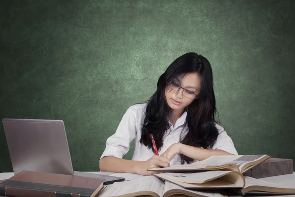 Beautiful learner doing school task in class — 图库照片