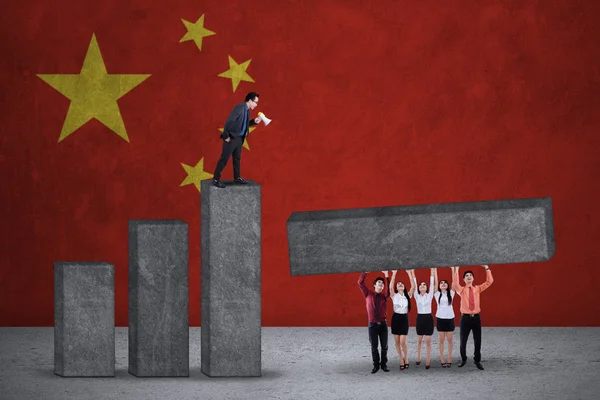 Businesspeople build graph with chinese flags — Stockfoto