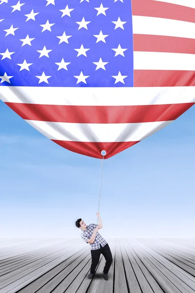 Caucasian person pulling down american flag — Stock fotografie