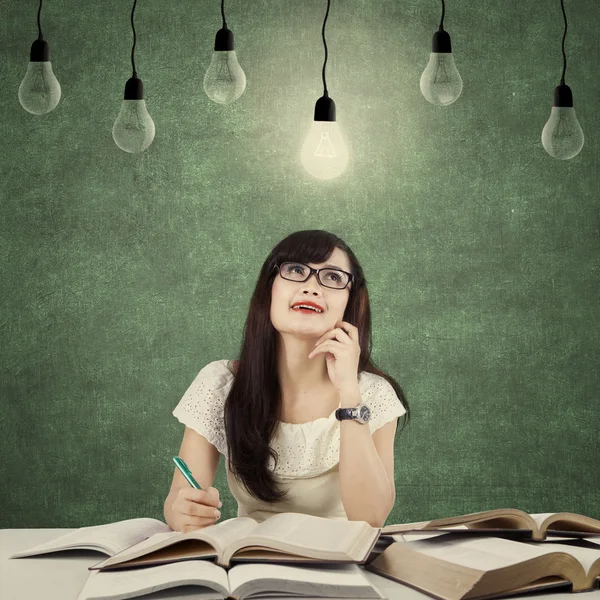 Clever student get inspiration under light bulb — Stockfoto