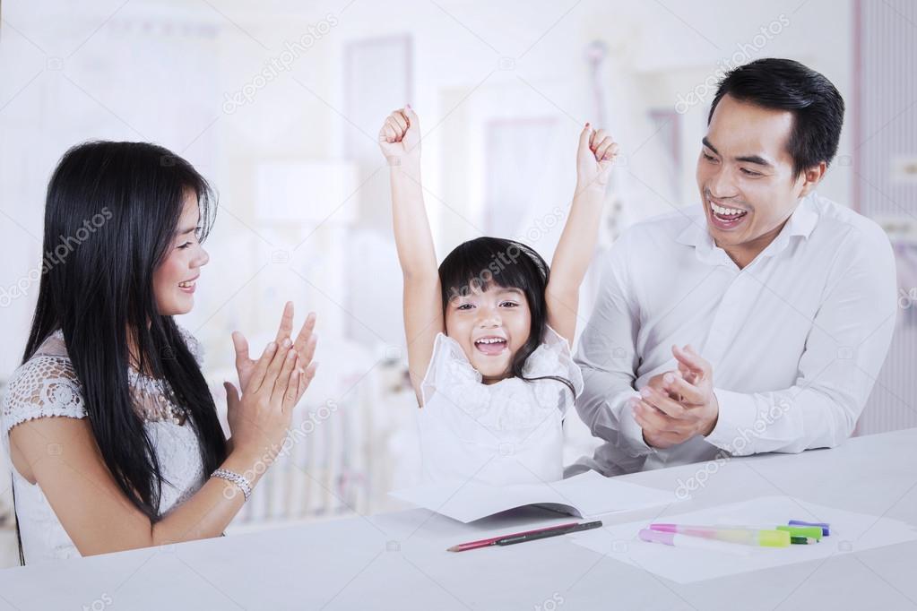 Cheerful kid getting applause from her parents