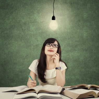 Student studying and get idea under light bulb