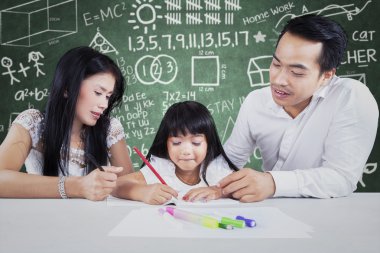 Student studying in the class with two teachers