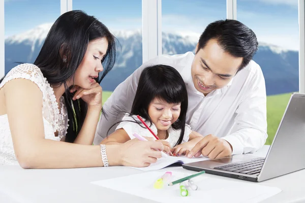 Chica feliz aprendiendo con sus padres — Foto de Stock