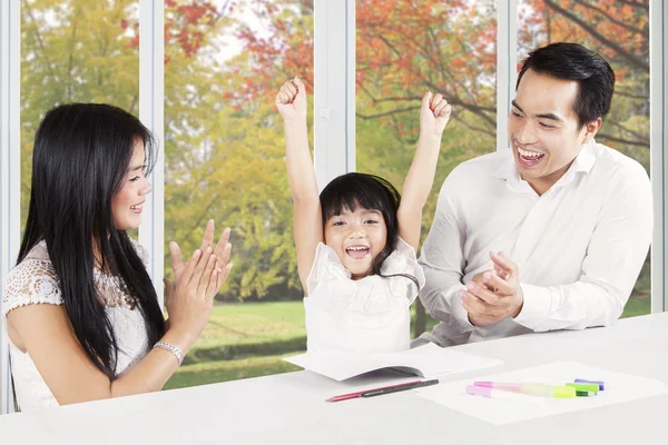 Pais felizes aplaudindo sua filha — Fotografia de Stock