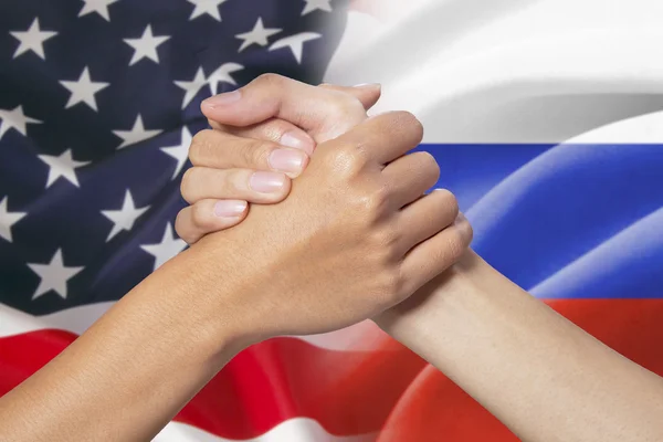 Partnerschaftshände mit amerikanischen und russischen Flaggen — Stockfoto