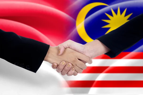 People handshake with indonesian and malaysian flags — Stock Photo, Image