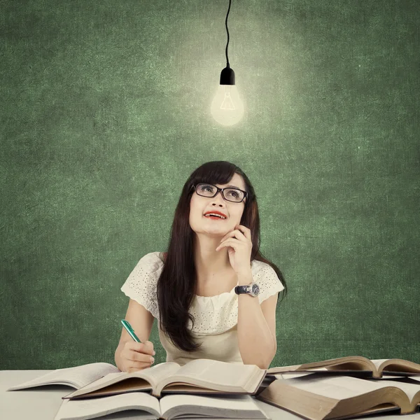 Student studying and get idea under light bulb — Stok fotoğraf