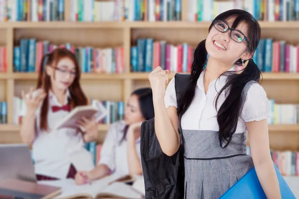 Estudante de sucesso com seu grupo na biblioteca — Fotografia de Stock