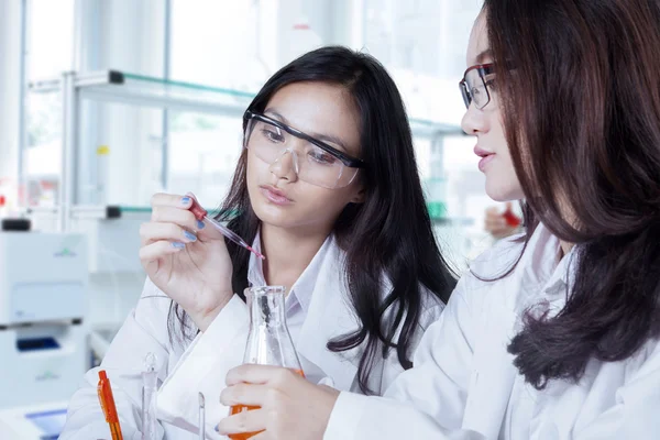 Two female scientists doing experiment — Zdjęcie stockowe