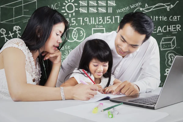 Two parents teach their child in the class — Stockfoto