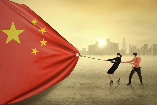 Two workers pulling a chinese flag — Stockfoto
