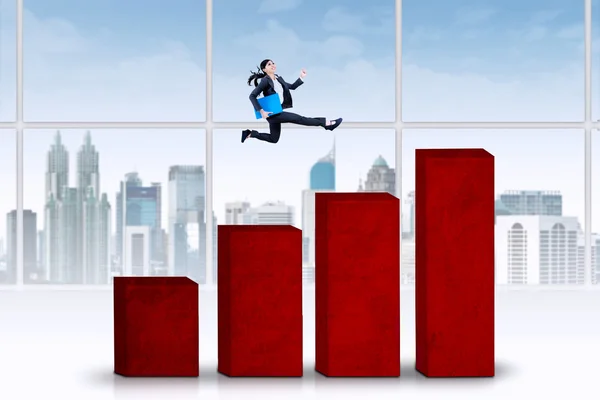 Empresária salta sobre o gráfico de negócios — Fotografia de Stock