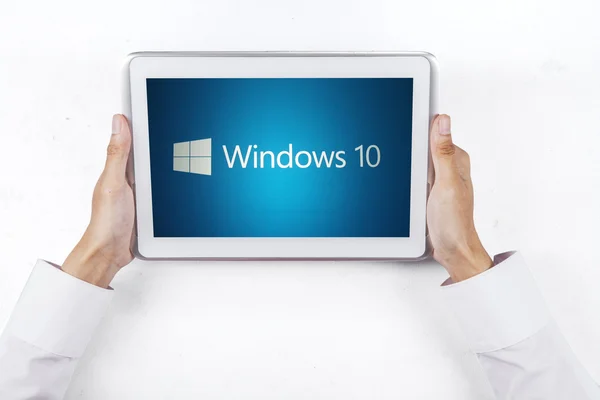 Manos sosteniendo una tableta con el logotipo de windows 10 — Foto de Stock