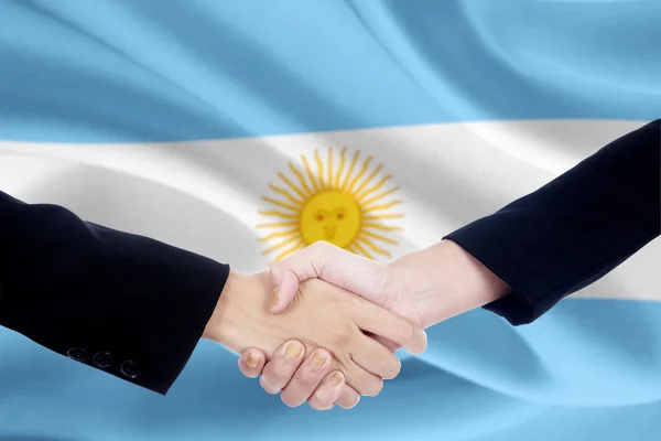 Handshake a argentina pozadí vlajky — Stock fotografie