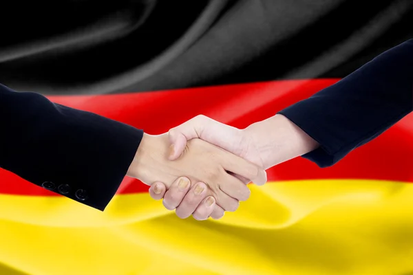 Χειραψία πέρα από το υπόβαθρο σημαία της Γερμανίας — Φωτογραφία Αρχείου
