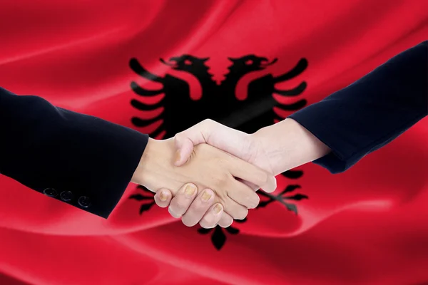 Aperto de mão com fundo bandeira albaniana — Fotografia de Stock