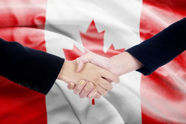 与加拿大国旗背景握手 — 图库照片