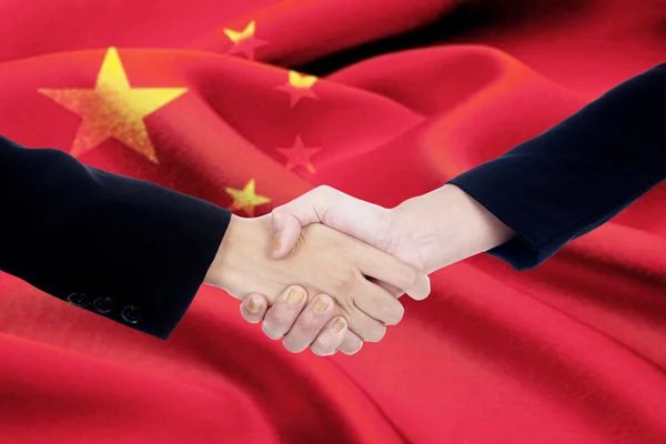 与中国国旗背景握手 — 图库照片