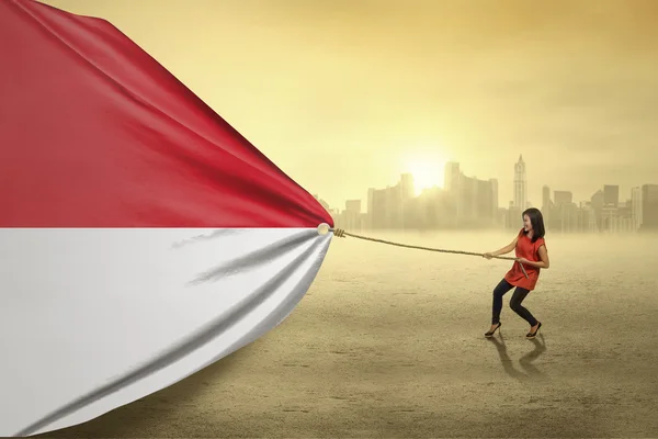 Mulher indonésia puxando uma bandeira — Fotografia de Stock