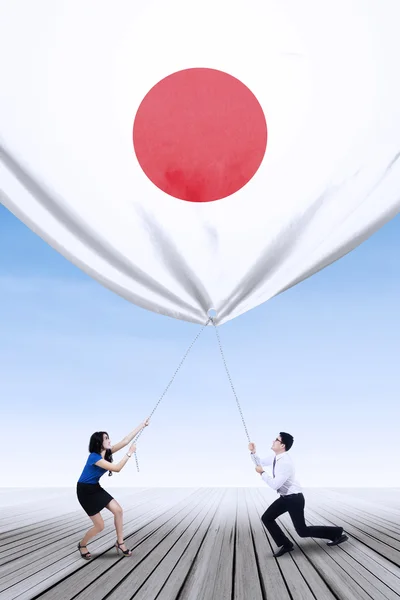 日本の労働者が日本の旗を降ろす — ストック写真