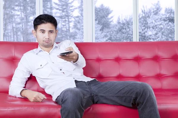 Man looks bored watching tv at home — Stock Photo, Image