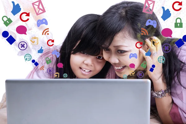 Mother showing e-mail on laptop to daughter — Stock Photo, Image