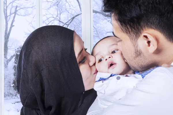 Föräldrar kyssa deras baby kinder — Stockfoto