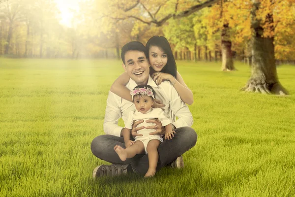 Ouders met dochter zit op herfst veld — Stockfoto