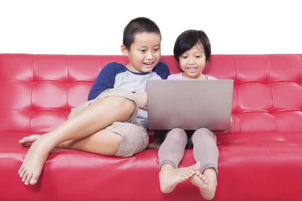 Dos niños viendo la película junto con el ordenador portátil — Foto de Stock