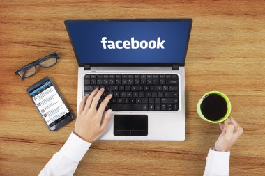 Facebook logosu ile çalışan el laptop