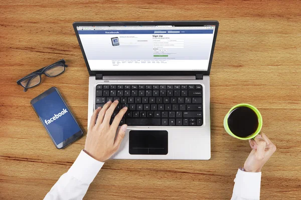 Facebook site on the laptop with worker hands — Stockfoto