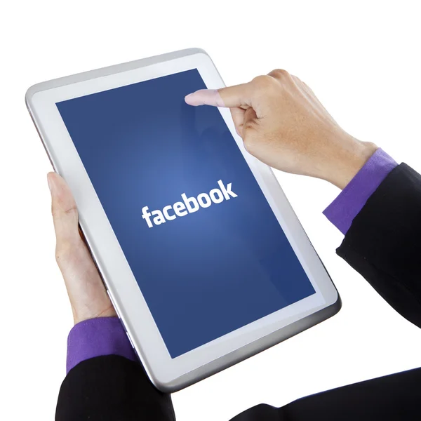 Finger touching tablet screen with facebook logo — Stockfoto