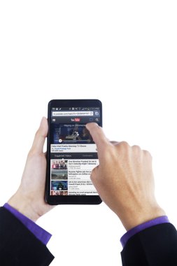 Finger touching cellphone screen with youtube webpage