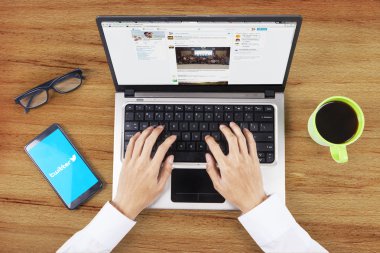 Hands open twitter profile on notebook computer