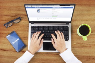 Hands opening facebook login page on laptop
