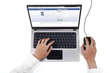 Hands using laptop to open facebook homepage