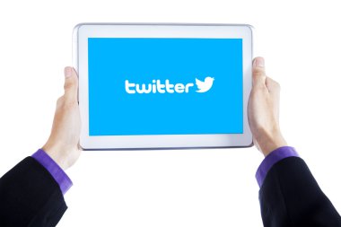 Hands with twitter site logo on tablet