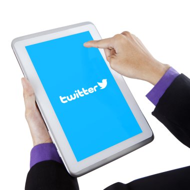 Person touching tablet screen with twitter logo