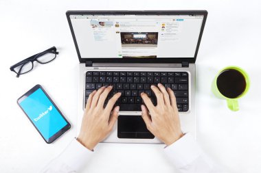 Worker hands open twitter site on laptop