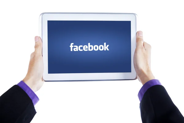 Hands holding tablet with facebook logo on screen — Stockfoto