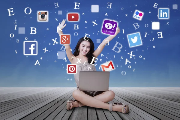 Happy girl using laptop to access social media sites — ストック写真