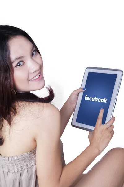 Lovely girl holds tablet with facebook logo — Zdjęcie stockowe