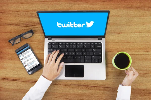 Twitter-Logo auf dem Laptop und Geschäftsmann Hände — Stockfoto