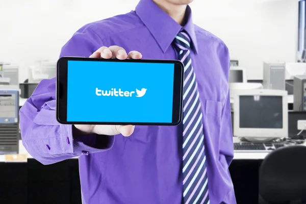 Arbeiter zeigt Twitter-Logo im Büro — Stockfoto