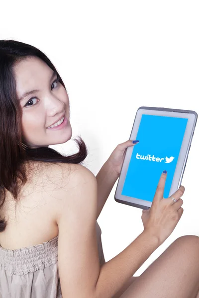 Young girl holding tablet with twitter logo — Stockfoto